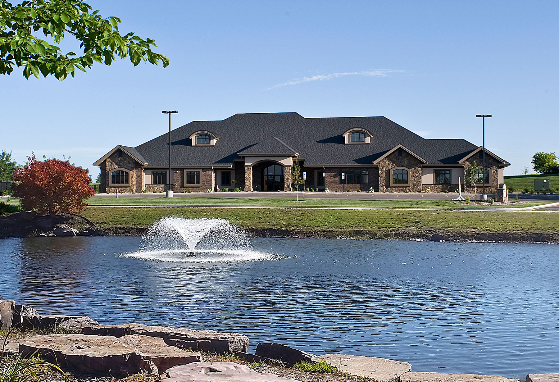 Exerior of Pinnacle Wealth Management building with large pond with fountain